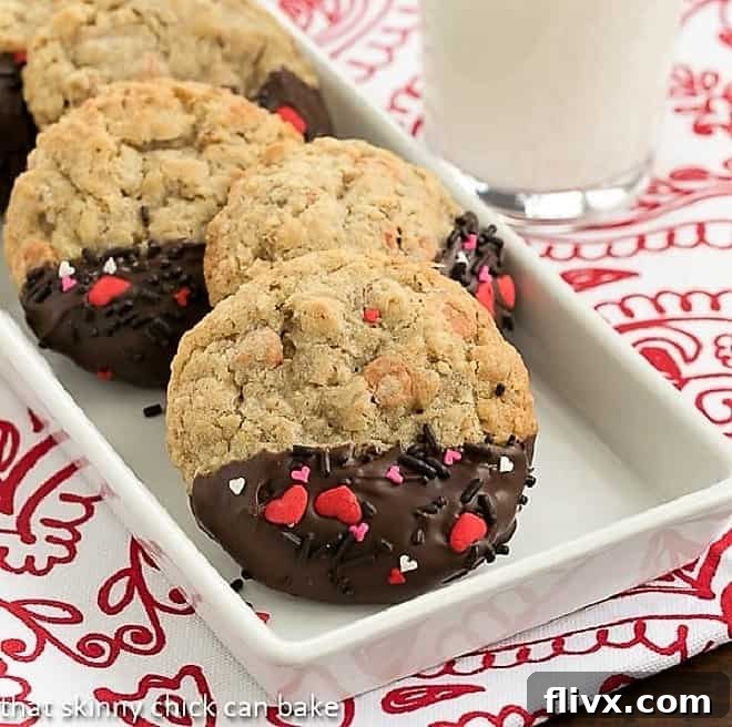 A rectangular white ceramic dish filled with golden-brown Big Dipper Oatmeal Butterscotch Cookies, some dipped in chocolate and decorated with festive sprinkles.