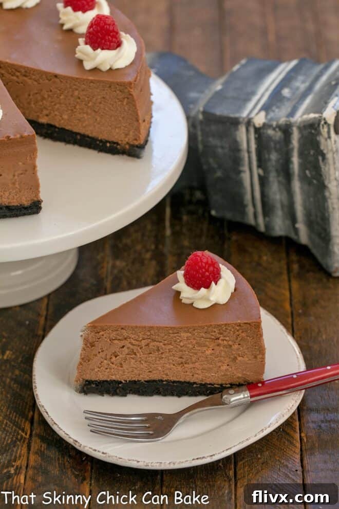 Slice of Italian Cheesecake on a white plate in front of the remaining cheesecake on a cake stand, garnished with berries.