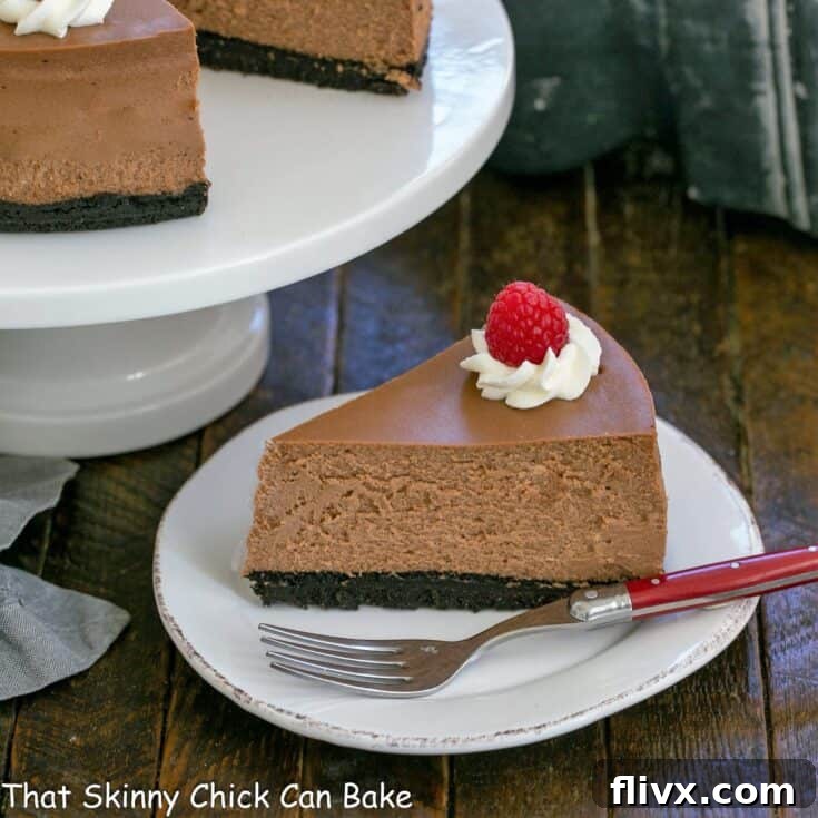 Slice of chocolate mascarpone cheesecake with a red handled fork on a white plate, ready to be enjoyed.