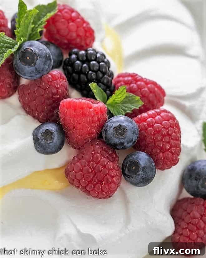 Vibrant fresh berries and mint on top of a meringue shell,