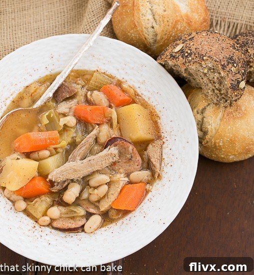 French Garbure Stew overhead shot with dinner rolls, ready to be served.