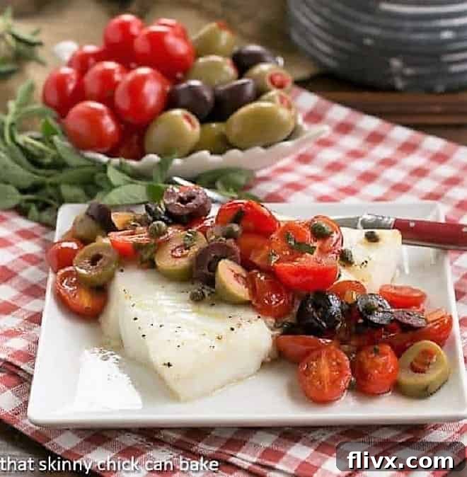 Sea Bass with Tomatoes, Olives and Capers on small square plate with fork.