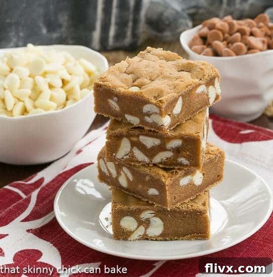 Butterscotch Blondies with White Chocolate Chips stacked on a white plate
