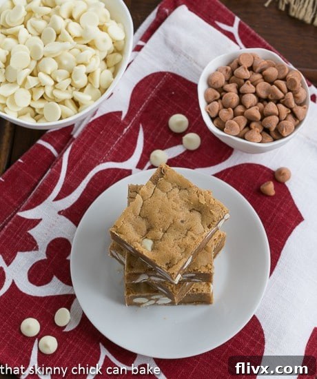 Overhead view of Butterscotch Blondies with White Chocolate Chips stacked on a white plate on a red and white napkin
