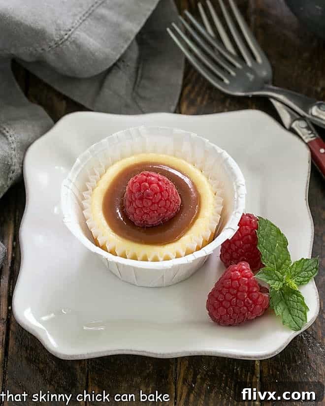 Mini Vanilla Cheesecakes can be garnished however you'd like! These are topped with caramel sauce and a beautiful ripe raspberry.