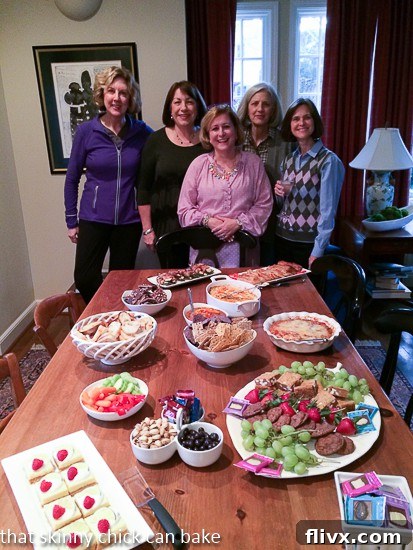 A vibrant book club spread featuring various finger foods and drinks, surrounded by friends enjoying the gathering.