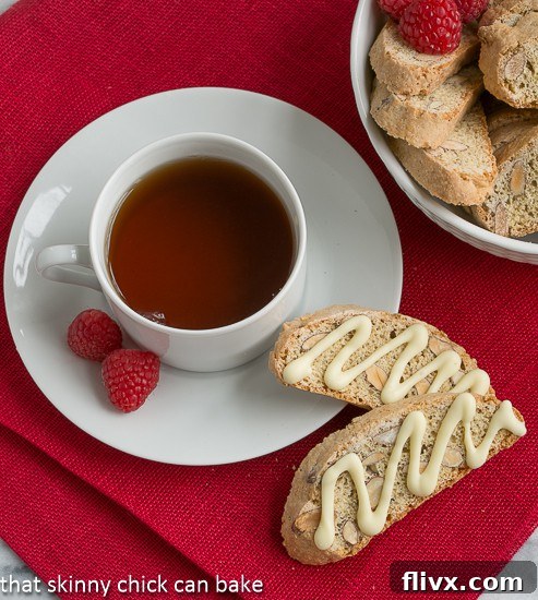 An inviting overhead shot of two perfect Cantucci or Almond Biscotti resting beside a cozy cup of tea, ready for a delicious break.