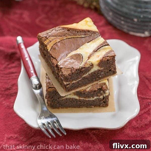 Two delectable Ricotta Cheesecake Brownies presented on a square white plate, accompanied by a fork. The fudgy brownie base is crowned with an irresistible cheesecake swirl, promising a delightful blend of textures and flavors.