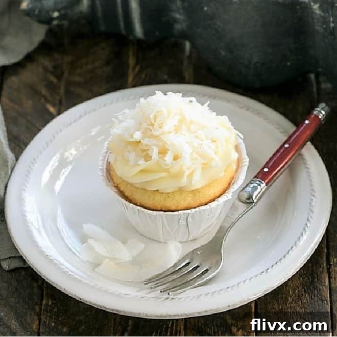 featured image of moist coconut cupcakes with cream cheese frosting, garnished with shredded coconut
