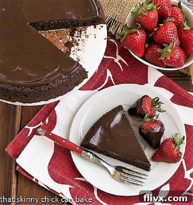 Close-up of a Flourless Double Chocolate Cake slice on a white plate with a red-handled fork, showing the dense interior.