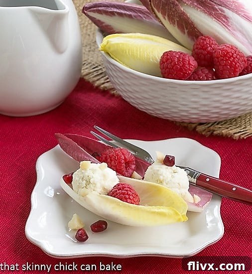 Endive Cups with Blue Cheese, Raspberries and Macadamia Nuts on a white plate, ready to be served.