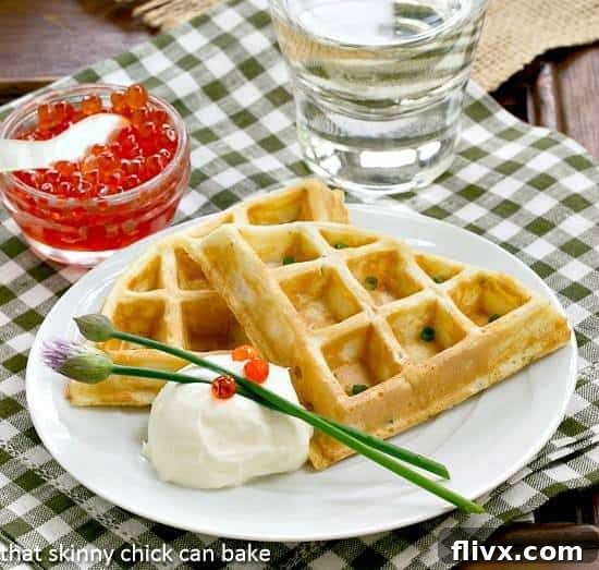 Elegant Smoked Salmon Waffles - A Savory Brunch Innovation! Smoked Salmon Waffles on a white plate with creme fraiche, salmon roe and chive blossoms.
