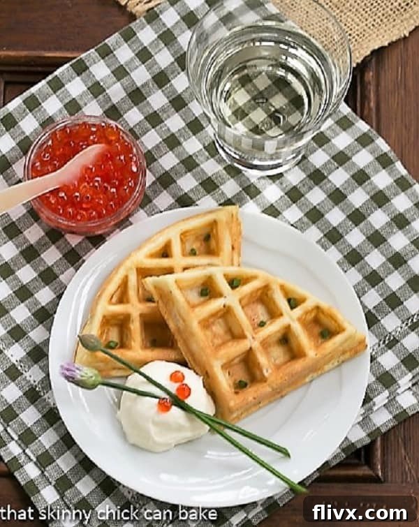Perfectly Crispy Smoked Salmon Waffles Smoked Salmon Waffles on a white plate from above, garnished with chives and roe.