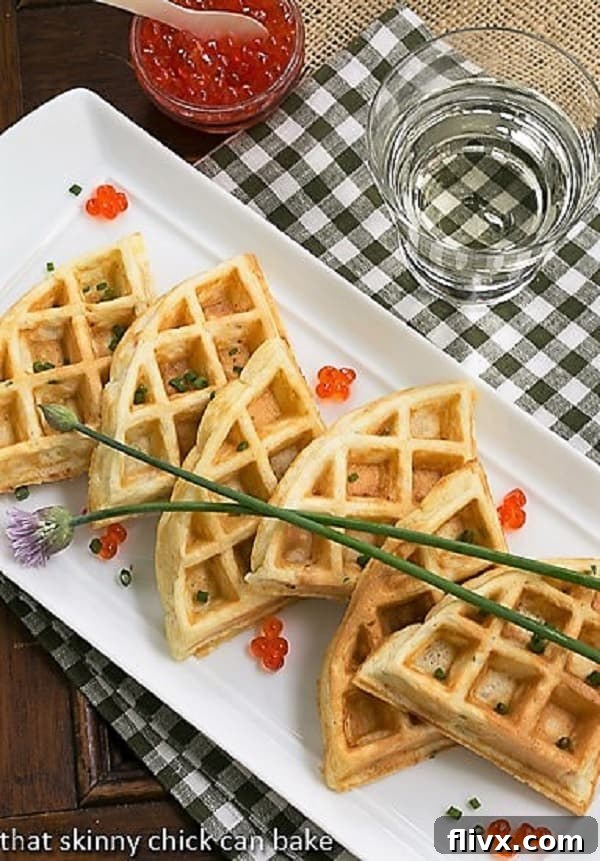 Presentation Perfection: Smoked Salmon Waffles Tray Smoked Salmon Waffles lined up on a white serving tray with chive blossoms and salmon roe.