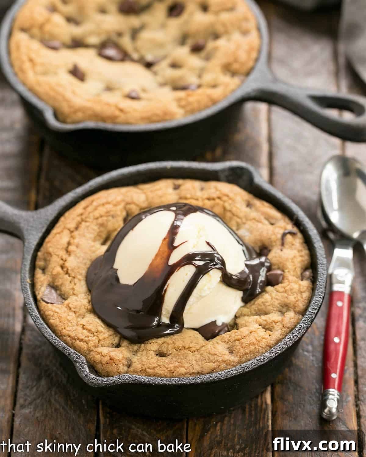 Big pizza cookie in a cast iron skillet topped with melting vanilla ice cream and chocolate sauce, ready to be served.