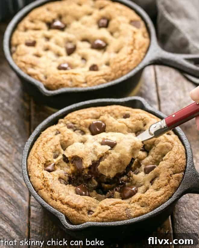 Two warm pizookies with one being scooped, showcasing the gooey chocolate chip center and ice cream.