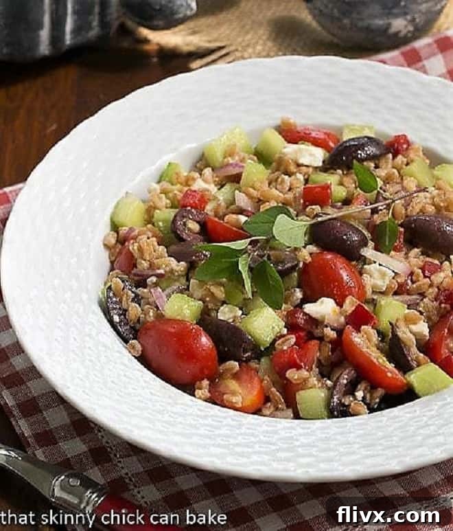 A beautifully presented Greek Farro Salad in a white basketweave bowl, ready to be enjoyed.