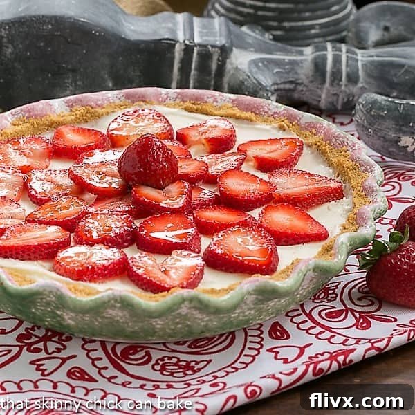 A beautifully presented Strawberry Cheesecake Ice Cream Pie, captured in a charming green and pink pie plate, ready to be served