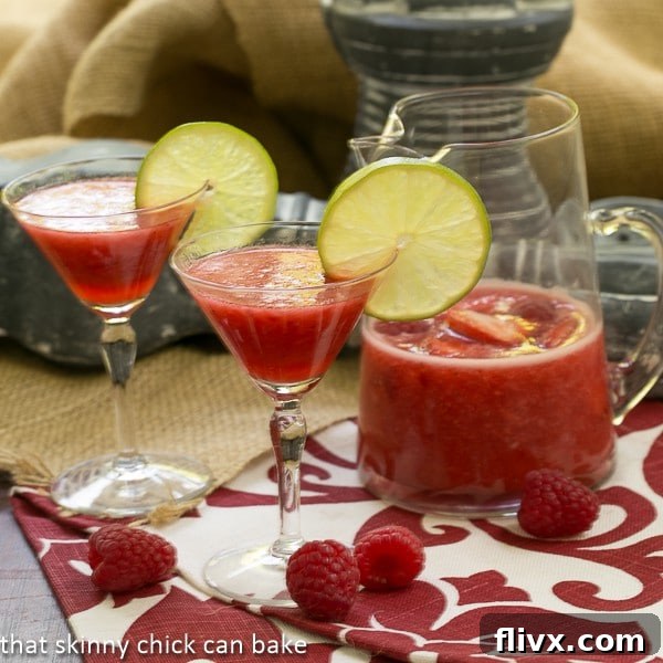 Berry Daiquiris in martini glasses garnished with lime slices and fresh berries