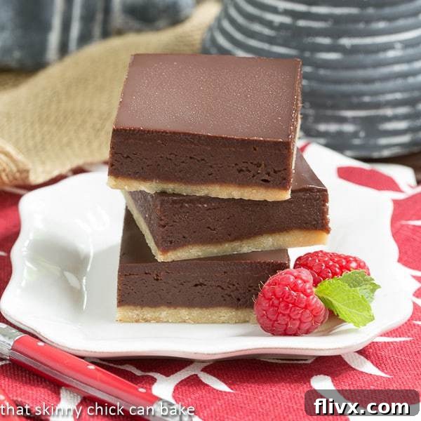 A stack of three decadent Truffle Brownies on a white square plate, showcasing their rich layers.