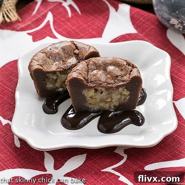 German Chocolate Brownie Cupcakes on a white dessert plate, elegantly drizzled with fudge sauce.