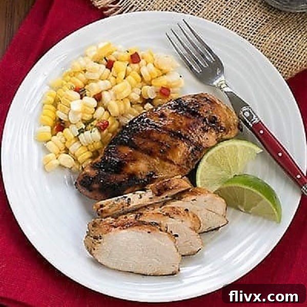 An inviting overhead view of a dinner plate featuring exquisitely marinated and grilled chicken, fresh side dishes, and vibrant lime wedges for garnish.