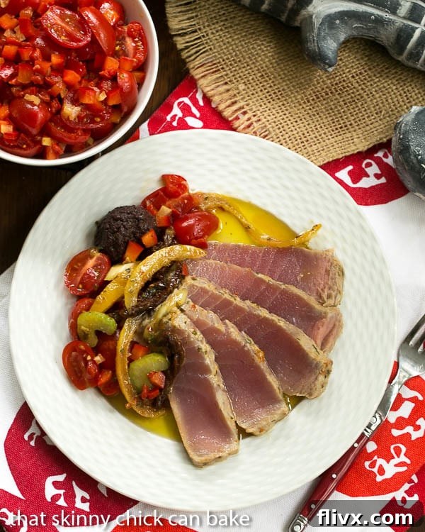 Close-up of delicately sliced Tuna Confit alongside Black Olive Tapenade