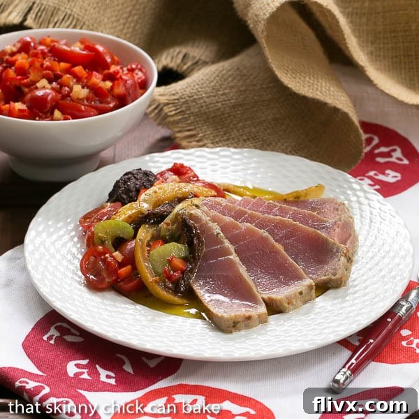 Plated Tuna Confit with garnishes and a glass of wine, ready to be served