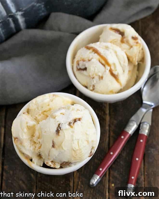 Overhead view of two small white bowls of vanilla caramel swirl ice cream, ready for serving.