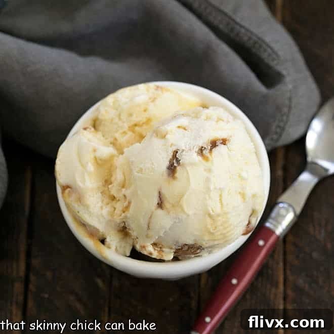 A beautifully presented bowl of homemade vanilla caramel swirl ice cream with a spoon.