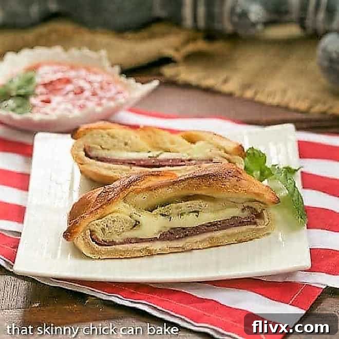 Braided Stromboli on a square white plate with a sprig of basil