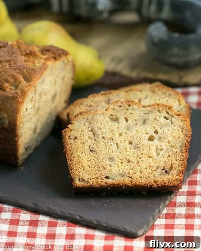 Sour Cream Pear Bread slices on a slate cutting board, showcasing the moist interior and pear chunks.