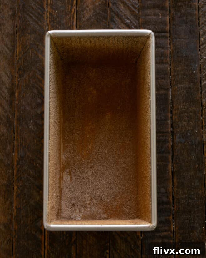Loaf pan prepped for pear bread by buttering and dusting with cinnamon sugar.