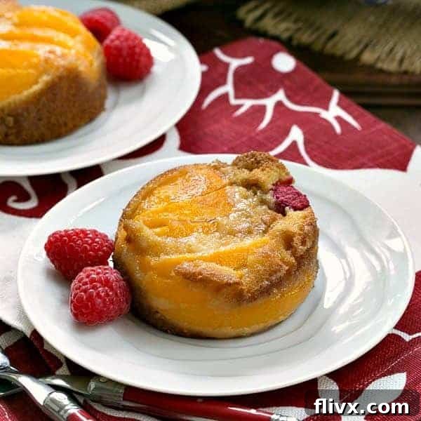 Oven Roasted Peach Cakes on white dessert plates with fresh raspberries.