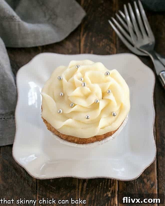 Overhead view of an Easy Vanilla Cupcake on a white plate, showcasing its fluffy texture and perfect frosting.