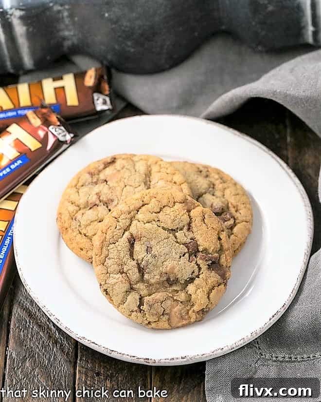 Several Brown Butter Toffee Cookies arranged on a round white plate, ready to be enjoyed.