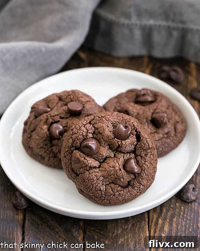 Three Double Chocolate Chunk Cookies presented beautifully on a clean white plate.