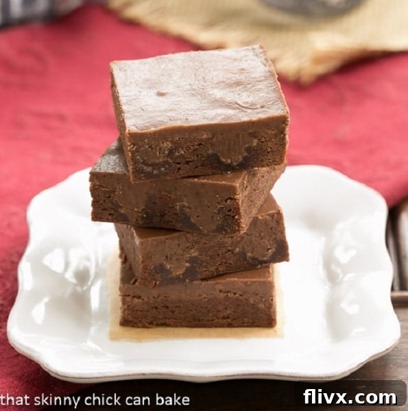 Rich Chocolate Poke Brownies drizzled with chocolate sauce and topped with whipped cream