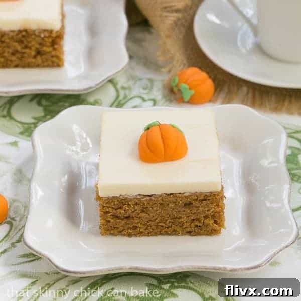 Pumpkin Bars with Cream Cheese Frosting topped with a decorative pumpkin candy