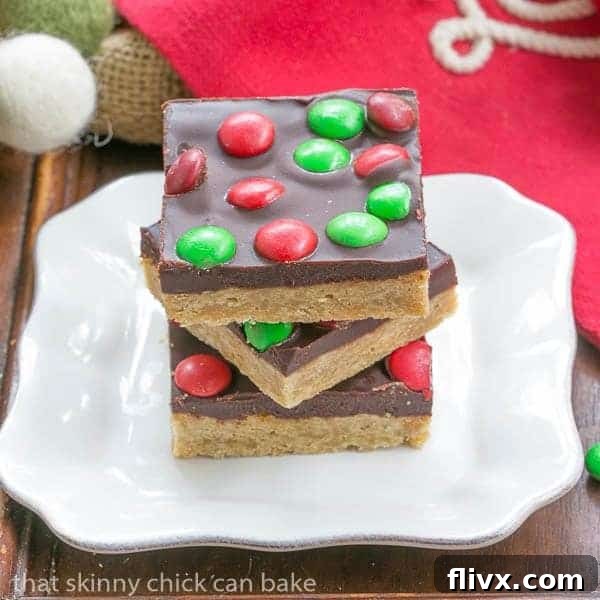 Candy Topped Toffee Squares stacked on a square white plate, showcasing their decadent layers.