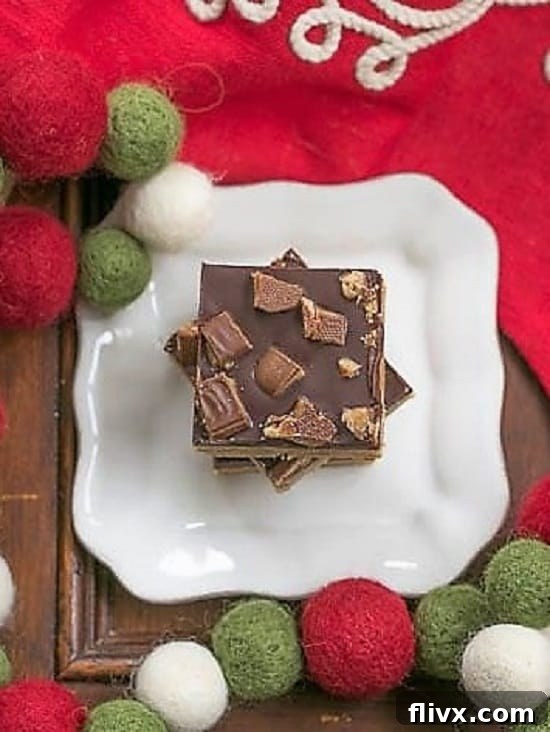 Overhead view of Candy Topped Toffee Bars on a square white plate, showing the three distinct layers clearly. 