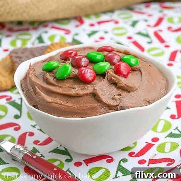 Brownie Batter Dip in a white bowl topped with colorful M&M's, ready for serving