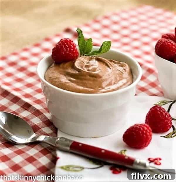 Classic French Chocolate Mousse with Grand Marnier in a pristine white ramekin, with a red-handled spoon resting beside it, inviting a taste.
