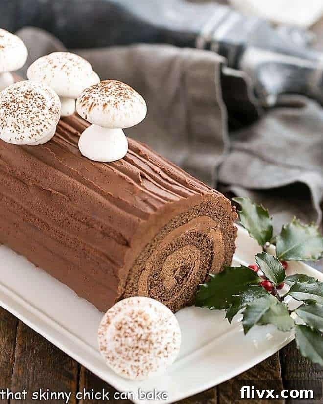 A beautifully decorated Bûche de Noël (Yule Log), covered in chocolate ganache and festive mushrooms.