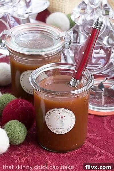 Freshly made Microwave Caramel Sauce glistening in glass jars, accompanied by a festive red-handled serving spoon.