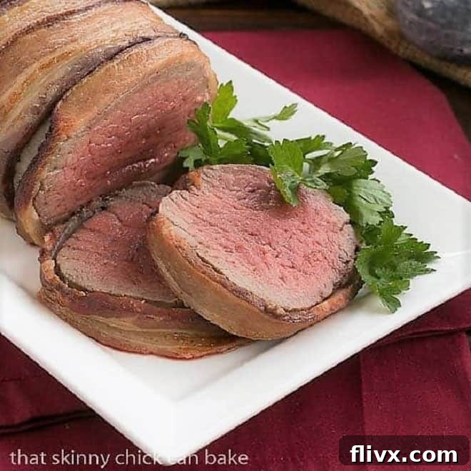 Two generous slices of succulent beef tenderloin, beautifully wrapped in crispy bacon, ready to be served.