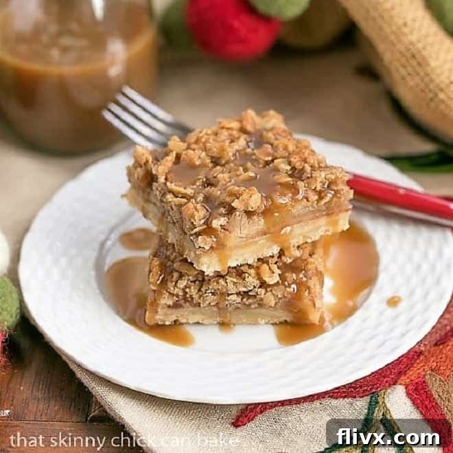 Caramel Apple Streusel Bars stacked on a white plate and drizzled with caramel, showcasing their golden-brown streusel topping and inviting texture.