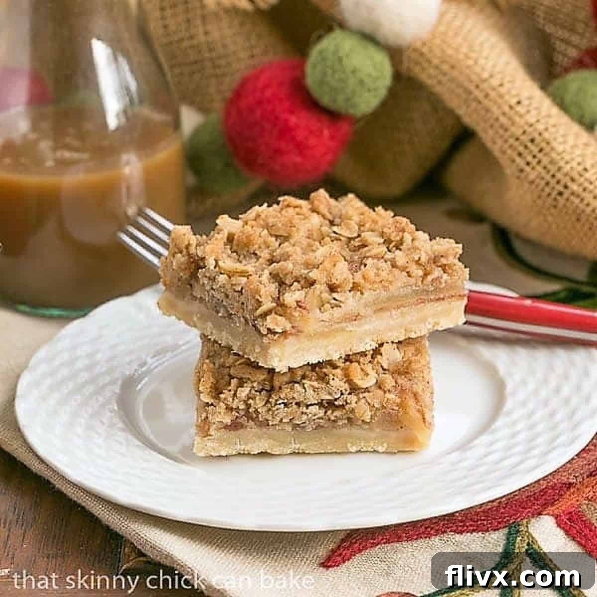 Stacked Apple Streusel Bars on a white dessert plate, showing the layers of crust, apple, and crumb topping.