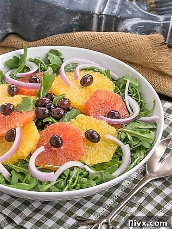 A beautifully composed Orange Olive Moroccan Salad on a bed of fresh arugula, served in a white bowl, resting on a charming checked napkin, highlighting its rustic elegance.