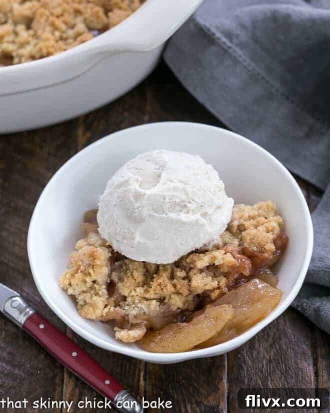 Apple crisp served with a scoop of vanilla ice cream, ready to be enjoyed.